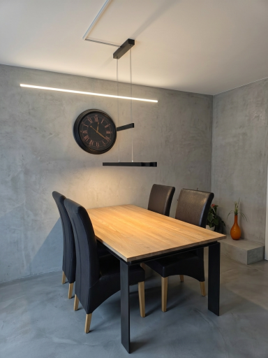 Esszimmer-Einrichtung & Lampenmontage Moderner Holzesstisch mit Stühlen, einer Design-Uhr und einer hängenden Design-Lampe.
